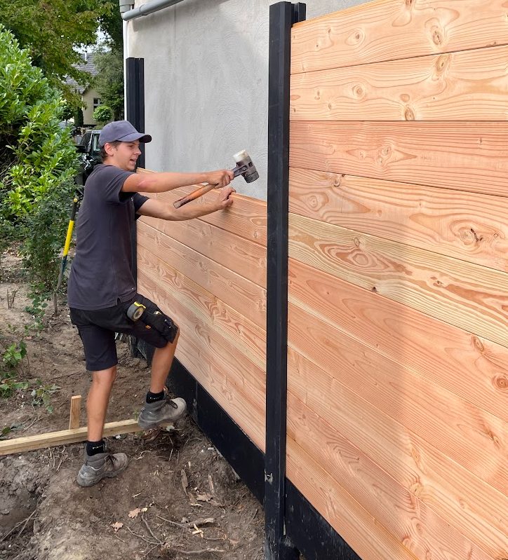 Plaatsen van een houten schutting door de hovenier